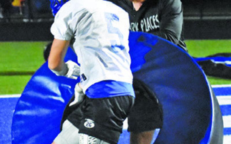 MICHAEL EATON is pictured with Coach Nolan Lanham working on this Friday night drill.