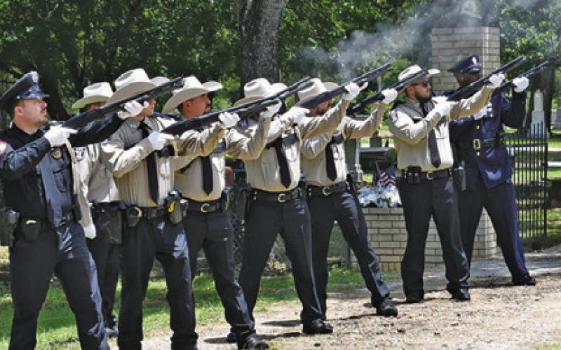 THE RIFLE HONOR Guard fires a salute for Sheriff Gene Hermes.