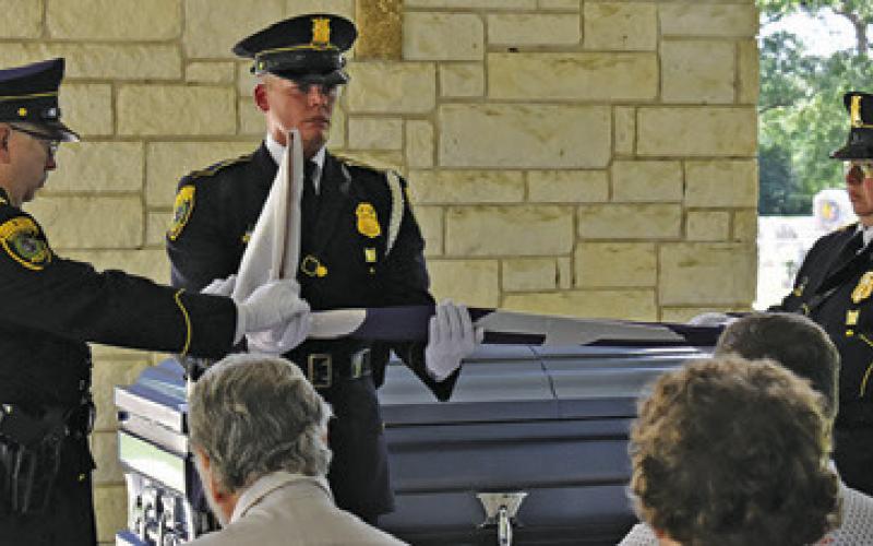 HOUSTON POLICE DEPARTMENT officers fold the flag at the burial site for Sheriff Gene Hermes at Providence Baptist Church Cemetery. Tribune photo by Roy Sanders