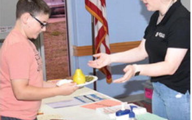 MEGAN ROGERS, 4-H and youth development agent with Texas A&amp;amp;M AgriLife Extension, hands this plate to Xavier Gutierrez at the Feb. 22 program “A Fresh Start to a Healthier You” at the Caldwell Civic Center.