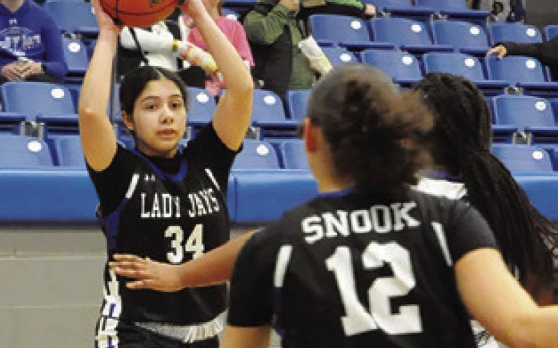 ASHLEY QUEVEDO looks to pass the ball to a teammate during the Snook-Mumford game last Friday night in Mumford. Tribune photo by Denise Squier