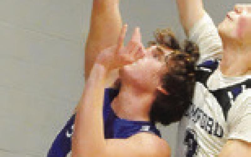 BRAYDEN MACIK of Snook shoots despite defensive pressure against Mumford. Tribune photo by Denise Squier