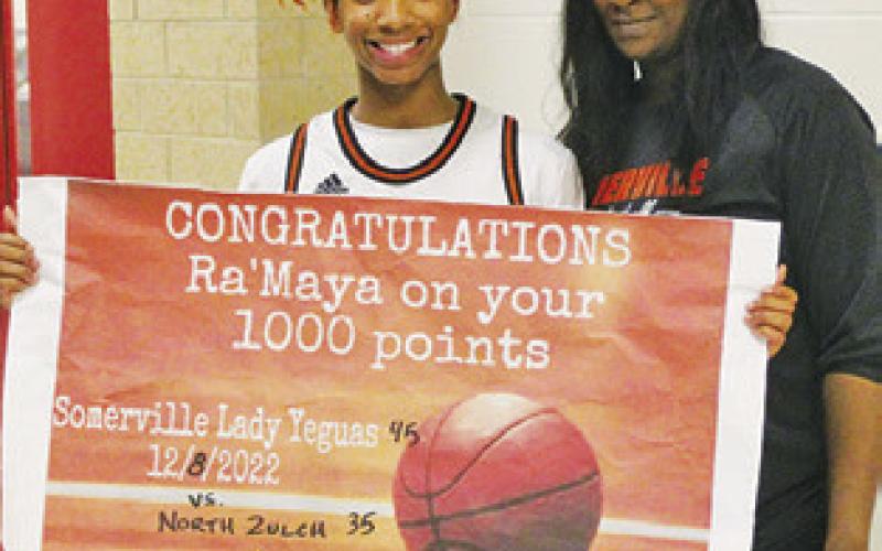 RA’MAYA CARTER IS pictured with Coach Alicia Ellis after Carter reached the 1,000-point milestone for basketball.