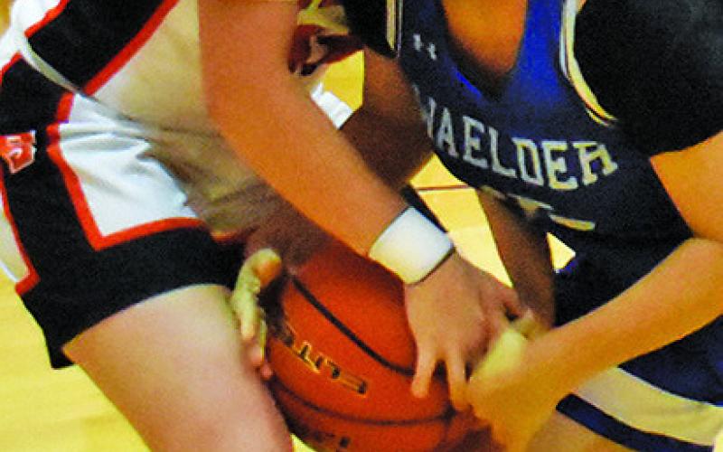 KYLIE NEUENDORFF battles with a Waelder player for possession of the ball during the Citizens State Bank Classic girls basketball tournament last week.