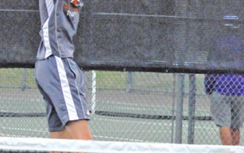 BREYDEN ATHEY backhands the ball during a boys’ singles match against a Thrall player last week. -- Tribune photo by Denise Squier