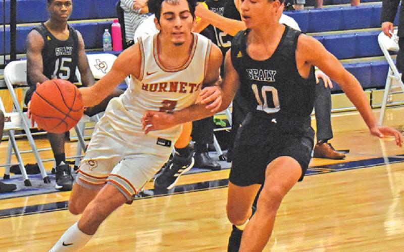 ZACK HEATON of Caldwell dribbles the ball against Sealy in the Hornets game last Friday.