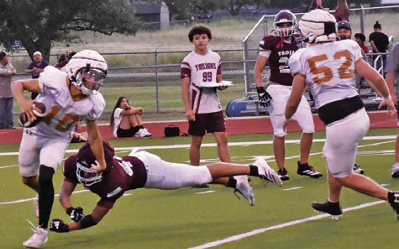 KORBIN BURNS BREAKS away from this Troy tackler and teammate Chase Clark moves in. Tribune photo by Roy Sanders