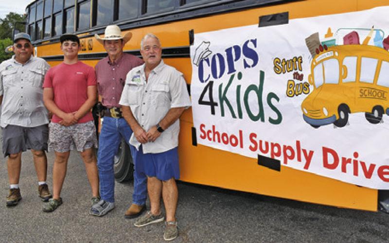 HELPING WITH the Cops 4Kids School Supply Drive on Monday, Aug. 10, were, from left, Michael Hester, Wyatt Hester, Burleson County Sheriff Bill Rios and Peter Glidewell. The annual drive is also sponsored by Texas A&amp;amp;M AgriLife Extension Service.