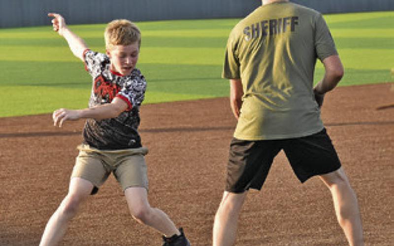 THE FIRST RESPONDERS vs. the Community slow pitch softball game drew plenty of players on Aug. 4 as part of National Night Out. Tribune photo by Roy Sanders