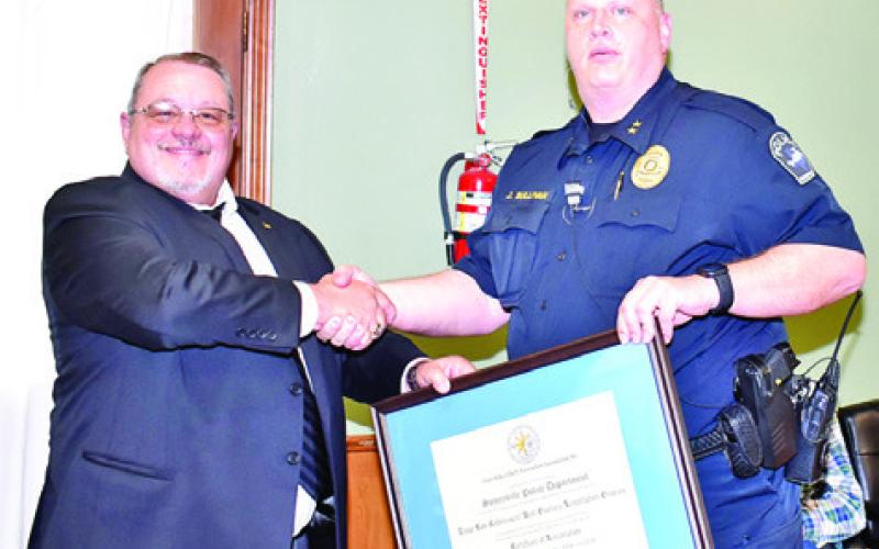 KEVIN LUNDSFORD, left, of the Texas Police Chiefs Association, presents the accreditation to Somerville Police Chief Jake Sullivan.