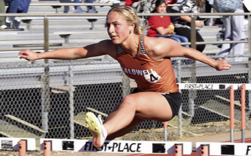 CALDWELL’S KAYLAN GROCE clears this hurdle during last week’s Happy Skrabanek Relays at Hornet Stadium. Tribune photo by Roy Sanders