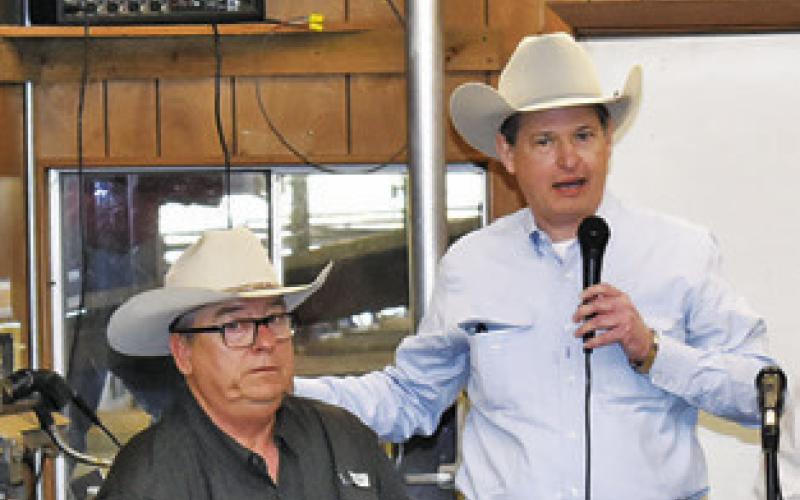 CARL RAY POLK JR., right, addresses the crowd as Milton Charanza listens at the Saturday sale at Caldwell Livestock Commission.