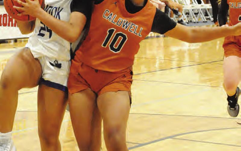 SNOOK’S ALANA Stringfellow is fouled by Caldwell’s Ava Jones during the fourth quarter of the Caldwell-Snook game in the Caldwell Lady Hornet Basketball Tournament last week.