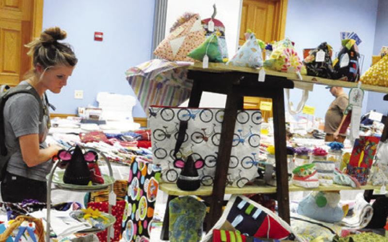 VISITORS TO THE CREATIVE Memories Quilt Guild show shopped in the guild’s Country Store -- filled with fabrics, crafts, pattern books and quilted items for sale -- at the Caldwell Civic Center. Tribune photo by Denise Squier