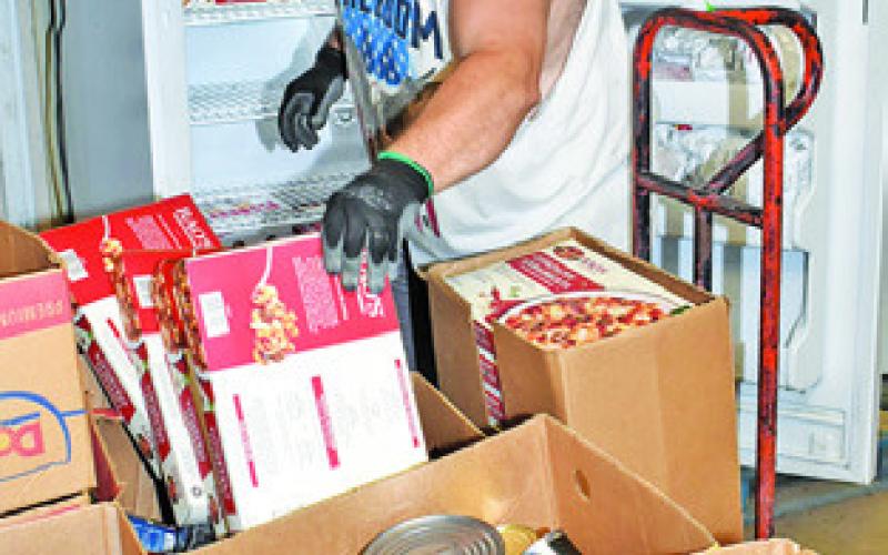 DAVID PALICKA sorts this food at the In God’s Hands Ministry Food Pantry.
