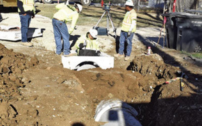 A CONSTRUCTION CREW works on drainage on Friday along F.M. 975. TxDOT is rebuilding the road from State Highway 21 to the railroad tracks.