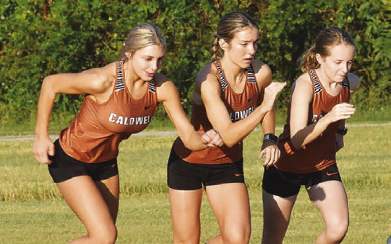 THE CALDWELL GIRLS VARSITY cross country team is pictured coming off the starting line for the girls varsity race at last Saturday’s Caldwell Cross Country Invitational at Davidson Creek. Pictured, from left, are Maddy Faust, Hannah Muzny and Fallyn Anderson. Tribune photo by Roy Sanders