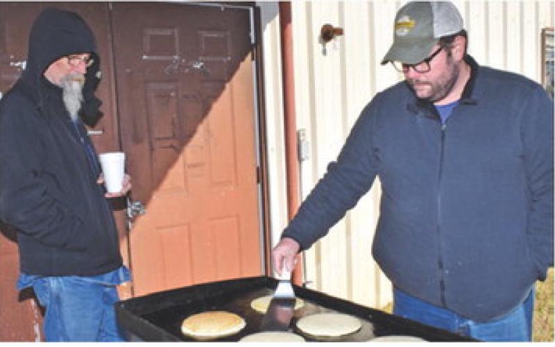 MIKE SMITH AND Scott Davis make pancakes last Saturday morning at the Chriesman Community Center. The free pancake breakfast, including coffee, was offered to the community. Tribune photo by Roy Sanders
