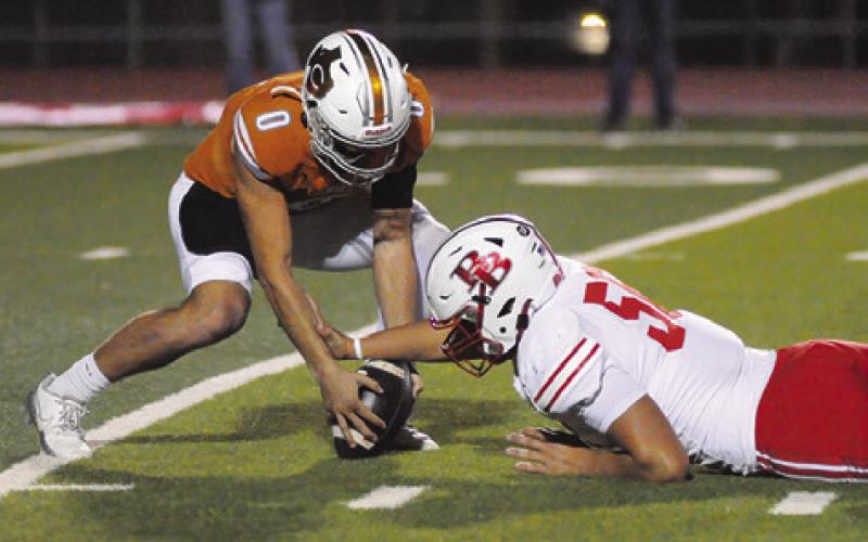 COY BECKA OF Caldwell reaches for this loose ball against Bellville. Tribune photo by Denise Squier