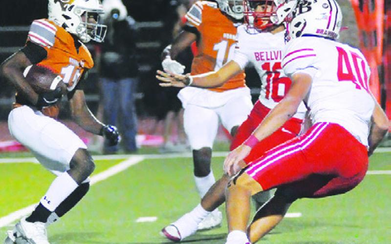 CALDWELL’S DEJUAN MATHIS carries the ball against Bellville. Also pictured is teammate Kory Murray. Tribune photo by Denise Squier