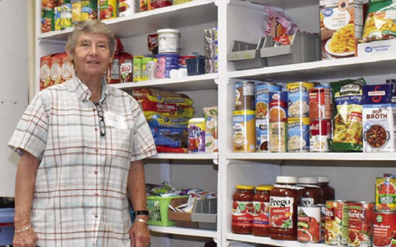 DIANE GANSKE STANDS next to this large display of canned goods at the SAAM House at their open house on Saturday, Nov. 15.