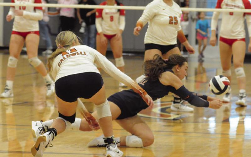 CALDWELL LIBERO NATALIE EASTEPP dives for the ball during the Caldwell-Bellville match on Friday. Also pictured are, Reese McManus and Kierstyn Macik. Tribune photo by Denise Squier