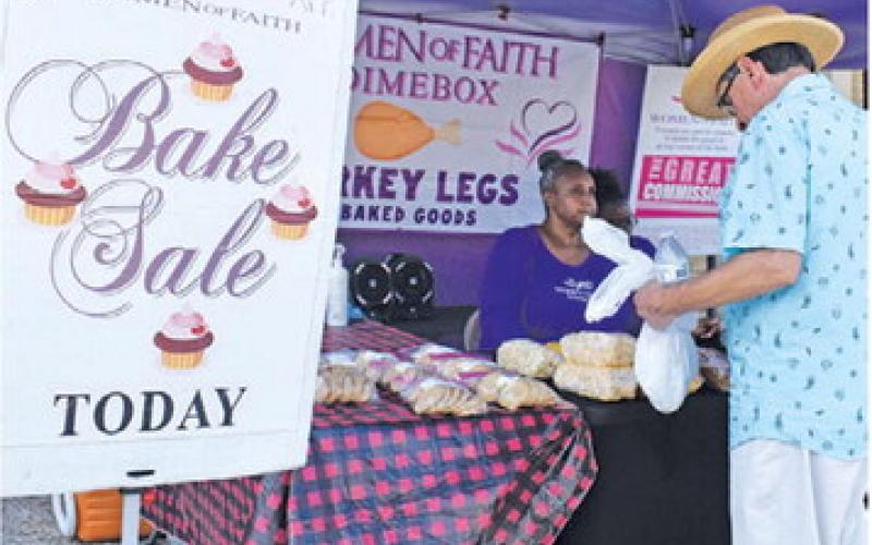 VENDORS GREET A customer on Saturday at the festival.