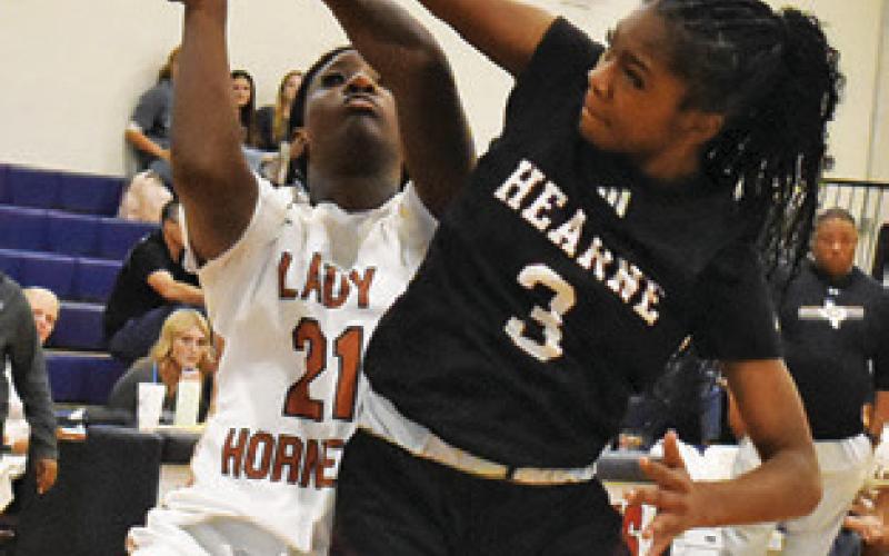 MESHA JOHNSON attempts a layup while a Hearne player defends during the annual Lady Hornet Classic last week. Tribune photo by Roy Sanders