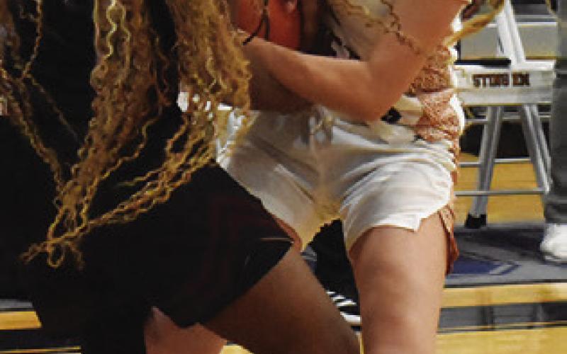 MAYZI WITHERWAX struggles to get the ball from a Hearne player during the Lady Hornet Classic last week in Caldwell. Tribune photo by Roy Sanders