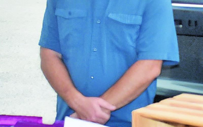 JUSTIN MILLS of Hippo Farms works on Saturday morning during the Farmers Market at the courthouse square in Caldwell.