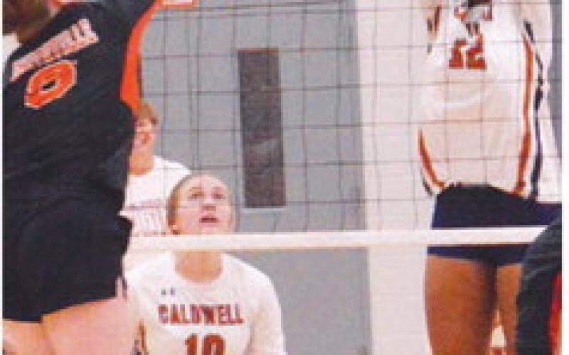 CALDWELL’S TYNIAH JOHNSON reaches to block a Lady Tiger hit while Kelly Urbanovsky looks on during the Caldwell-Smithville match last week at Hornet Gym. -- Tribune photo by Roy Sanders