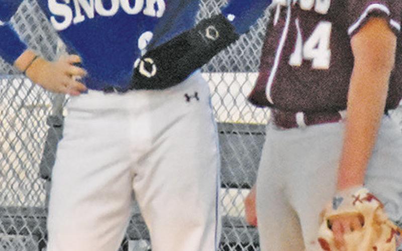 CADEN SCHLUENS is at first base against Iola last Friday in Caldwell.