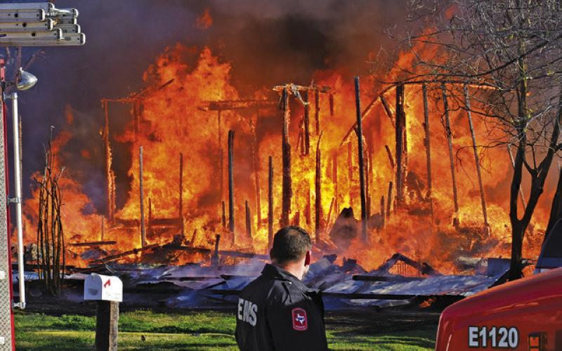 THE HOUSE AT 508 N. Hill Street burns as firefighters respond on Sunday morning. The house and contents were a total loss. -- Tribune photo by Roy Sanders