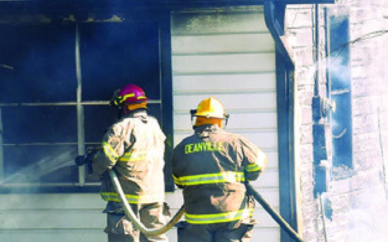 FIREFIGHTERS WORK around the corner of this house on Sunday morning.