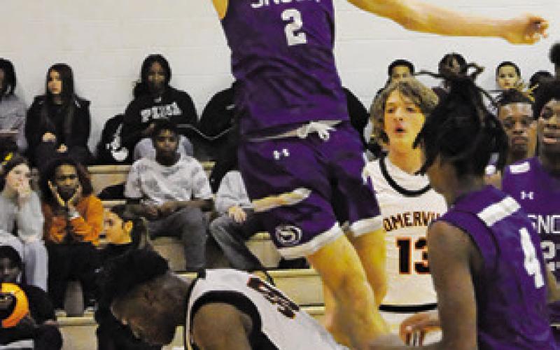 SOMERVILLE’S JAKEITH Daniels comes down with the ball as Snook’s Brett Withem jumps high. Snook won 51-36. Tribune photo by Denise Squier