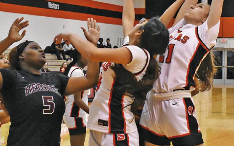 SOMERVILLE’S BRIDGET KALDIS grabs a rebound over several Somerville and Hearne players during the Lady Yeguas home game last Friday night at the Somerville High School Gym. Tribune photo by Roy Sanders