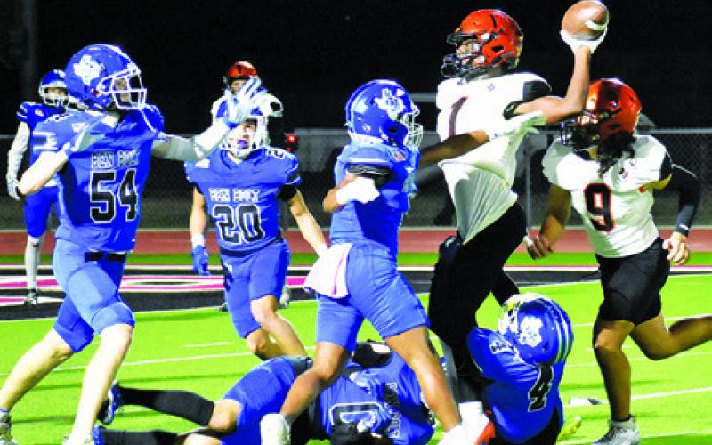 KEITH CRAWFORD HURLS this pass against Ben Bolt. Tribune photo by Roy Sanders
