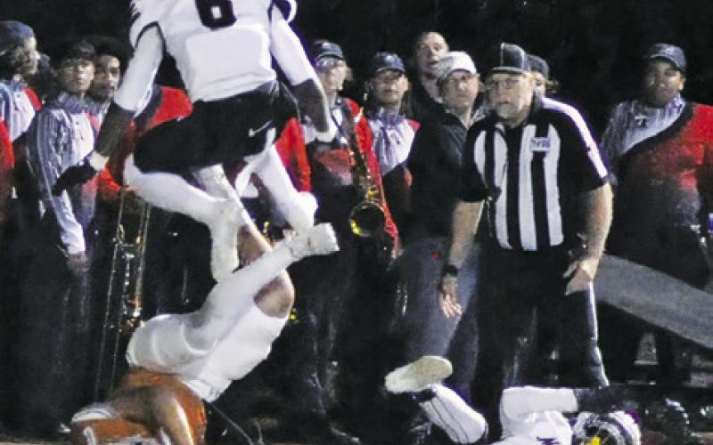 COY BECKA DIVES for yardage as these Madisonville players defend. Tribune photo by Denise Squier