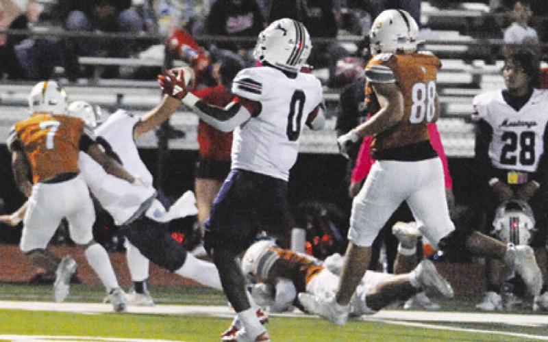CALDWELL’S DEFENSE moves in to tackle this Mustang ball carrier. Tribune photo by Denise Squier