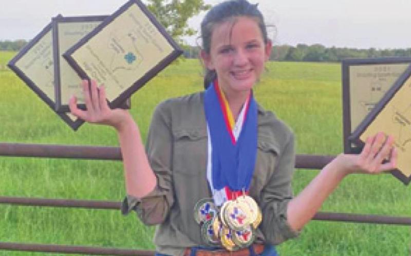 LORELAI BROWN shows her awards and medals she won at the 4-H Shooting Sport State Game. She placed in 16 of 23 events.