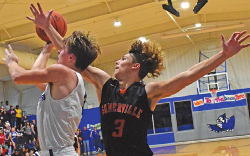 SNOOK’S SAM SMITHERMAN takes a shot as Somerville’s Johnny Legg defends. Snook on 70-51. -- Tribune photo by Roy Sanders