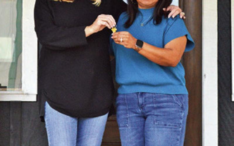 LISA BOREN OF The Farmhouse Twist hands over the keys to the Chamber of Commerce’s new office to Susan Mott, Chamber director. Tribune photo by Sabine Lazo