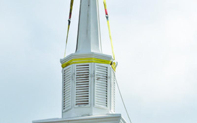 THE NEW STEEPLE is put in place at New Tabor Brethren Church last Wednesday. Tribune photo by Roy Sanders