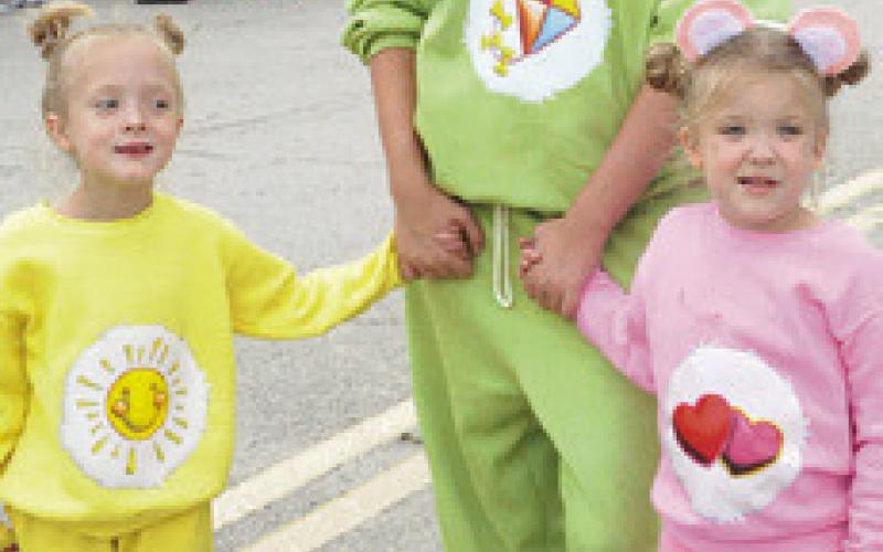 FAMILIES DRESSED in themes, such as Care Bears, at Saturday’s “Scare on the Square.” Tribune photo by Denise Squier
