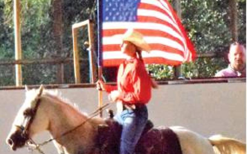 THE FLAG IS presented while the National Anthem is played during the opening ceremonies of the Saddle Club Youth Rodeo.
