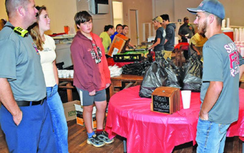 PLATES ARE PREPARED on Sunday, Aug. 23, for the Snook Volunteer Fire Department’s annual barbecue fundraiser.