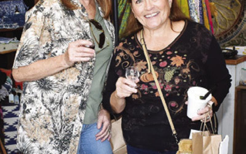 LINDA SHEELY and Susan Vajdak enjoy the “Toasting at the ‘Well” beer and wine walk last Saturday in downtown Caldwell.