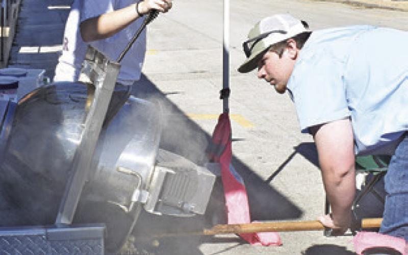 KETTLE CORN is prepared by Riley Broaddus and August Young on Saturday during the “Toasting in the ‘Well” celebration.