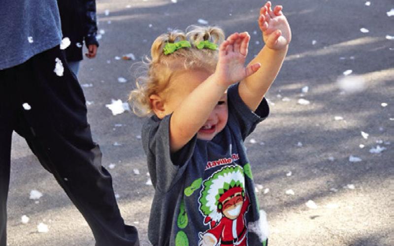 A YOUNG CHILD PLAYS in the “snow” at the 2023 Santaville event. Photo courtesy of Allyson Hargrove