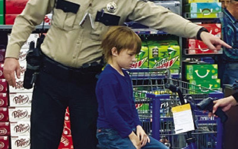 A CHILD ENJOYS HIS NEW BICYCLE while participating in the Shop with a Cop event. Tribune photo by Sabine Lazo